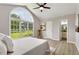 Serene main bedroom with large arched windows, a ceiling fan, neutral decor, and an attached bathroom at 117 S Woodstone Dr, Archer Lodge, NC 27527