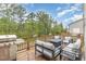 Relaxing back deck with a grill, patio furniture, and views of the lush greenery at 1172 Cottonsprings Dr, Wendell, NC 27591