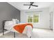 Bedroom featuring a bed with a white comforter, a gray accent wall, a ceiling fan and a window at 1172 Cottonsprings Dr, Wendell, NC 27591