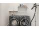 Well-lit laundry room featuring front load washer and dryer, white cabinetry, and shelving for storage at 1172 Cottonsprings Dr, Wendell, NC 27591