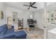 Bright office space with natural light, a blue sofa, ceiling fan, and modern desk setup at 1172 Cottonsprings Dr, Wendell, NC 27591