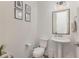 This is a half bathroom featuring a pedestal sink and decorative wall art at 1172 Cottonsprings Dr, Wendell, NC 27591