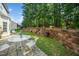 Backyard with tiered retaining wall, landscaping, and patio furniture for outdoor enjoyment at 121 Trevor Ridge Dr, Holly Springs, NC 27540