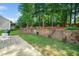 Backyard featuring a stone retaining wall with stairs and a paved patio at 121 Trevor Ridge Dr, Holly Springs, NC 27540
