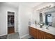 Bathroom featuring a dual sink vanity, large mirror, and access to a walk-in closet at 121 Trevor Ridge Dr, Holly Springs, NC 27540