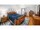 Cozy bedroom features a wooden bed frame with a dark blue comforter and hardwood floors at 121 Trevor Ridge Dr, Holly Springs, NC 27540