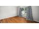 Bright bedroom with hardwood floors and curtains beside a large window with natural lighting at 121 Trevor Ridge Dr, Holly Springs, NC 27540