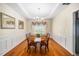 Formal dining room with wainscoting, wood table set for six, and decorative chandelier at 121 Trevor Ridge Dr, Holly Springs, NC 27540