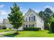 Side view of a beautiful two-story home featuring a well-maintained lawn and mature landscaping at 121 Trevor Ridge Dr, Holly Springs, NC 27540