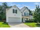Charming two-story home with a well-manicured lawn, two-car garage, and traditional architectural details at 121 Trevor Ridge Dr, Holly Springs, NC 27540