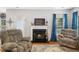 Cozy living room with a fireplace, comfortable seating, and natural light from a window at 121 Trevor Ridge Dr, Holly Springs, NC 27540