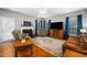Cozy living room featuring hardwood floors, a fireplace, comfortable seating, and abundant natural light at 121 Trevor Ridge Dr, Holly Springs, NC 27540