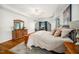 Large main bedroom with hardwood floors, dresser, desk, tray ceiling and seating area at 121 Trevor Ridge Dr, Holly Springs, NC 27540