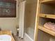 A well-appointed bathroom featuring tiled shower/tub combo and an open, rustic-style storage unit for linens and towels at 1225 Fairlane Rd, Cary, NC 27511