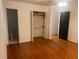 Bedroom with hardwood floors, closet with bifold doors, en suite half bath and a ceiling fan at 1225 Fairlane Rd, Cary, NC 27511