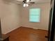 This cozy bedroom has hardwood floors, a ceiling fan, and plenty of natural light from the window at 1225 Fairlane Rd, Cary, NC 27511