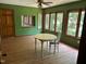 Dining area with hardwood floors, many windows for natural lighting, with green walls and a vintage light fixture at 1225 Fairlane Rd, Cary, NC 27511