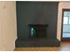 Unique black painted brick fireplace with hearth and glass enclosure is the focal point of the living room at 1225 Fairlane Rd, Cary, NC 27511