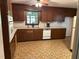 A kitchen featuring wood cabinets, laminate counters, an appliance package, and durable vinyl flooring at 1225 Fairlane Rd, Cary, NC 27511