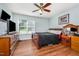 Comfortable bedroom featuring wood floors, a ceiling fan, natural lighting, and relaxing ambiance at 1261 Grovewood Dr, Clayton, NC 27520