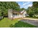 Exterior view of charming single-story home with a covered porch, front lawn, and mature trees at 1261 Grovewood Dr, Clayton, NC 27520