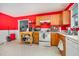 Bright kitchen with wooden cabinets, efficient appliances, and contrasting red walls, perfect for cooking at 1261 Grovewood Dr, Clayton, NC 27520
