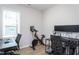 Functional office space with dual workstations, exercise bike, and natural light, perfect for working from home at 133 Black Cloud Dr, Louisburg, NC 27549