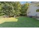 A spacious, green backyard featuring well-manicured lawn, a swing set, and white picket fence at 136 Vireo Ln, Hillsborough, NC 27278