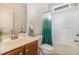 Cozy bathroom featuring a shower and tub combination with a teal shower curtain and a wooden vanity at 136 Vireo Ln, Hillsborough, NC 27278