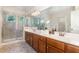 Bathroom offers a dual sink vanity, a large mirror, and a tiled glass shower at 136 Vireo Ln, Hillsborough, NC 27278