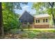 Exterior view of house, in woods, featuring a screened-in porch, with stone base and siding at 136 Vireo Ln, Hillsborough, NC 27278