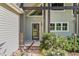 View of home's entrance featuring post and beam architectural detail, stone accents, and beautifully landscaped bushes at 136 Vireo Ln, Hillsborough, NC 27278