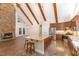 Open concept kitchen featuring a stone fireplace, wooden beams, island with seating, and stainless appliances at 136 Vireo Ln, Hillsborough, NC 27278