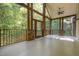 Spacious outdoor porch with wood ceiling, railing, beams, and door, all surrounded by foliage at 136 Vireo Ln, Hillsborough, NC 27278