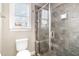 Bathroom with tiled walk-in shower, a clear glass enclosure, a toilet and a window for natural light at 14 Water Front Ln, Timberlake, NC 27583