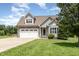 Charming gray two-story home with stone accents, a two-car garage, and a well-manicured front lawn at 14 Water Front Ln, Timberlake, NC 27583