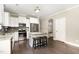 Bright kitchen with white cabinetry, stainless steel appliances, and a charming island with bar stools at 14 Water Front Ln, Timberlake, NC 27583