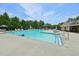 View of the community pool with clear water, surrounded by trees and lounge chairs at 1419 Endgame Ct, Wake Forest, NC 27587