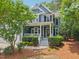 Inviting blue two-story home with a classic white porch, well-maintained lawn, and mature trees at 1419 Endgame Ct, Wake Forest, NC 27587