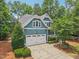 Charming blue two-story home featuring a two-car garage, manicured landscaping, and a welcoming front porch at 1419 Endgame Ct, Wake Forest, NC 27587