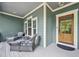 Close up of spacious front porch with comfortable seating, wood door, and stylish decor at 1419 Endgame Ct, Wake Forest, NC 27587