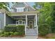 Charming covered front porch with white columns, hanging flower baskets, and a stained wood front door at 1419 Endgame Ct, Wake Forest, NC 27587