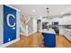 Open floor plan showing blue accent wall, stairs, hardwood floors, and kitchen with white cabinets at 1419 Endgame Ct, Wake Forest, NC 27587