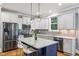 Bright kitchen with white cabinets, stainless steel appliances, granite countertops, and an island with bar seating at 1419 Endgame Ct, Wake Forest, NC 27587