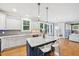 Open kitchen with white cabinets, stainless steel appliances, granite countertops, island, and hardwood floors at 1419 Endgame Ct, Wake Forest, NC 27587