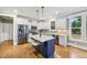 Modern kitchen with white cabinets, stainless steel appliances, a blue island, and granite countertops at 1419 Endgame Ct, Wake Forest, NC 27587