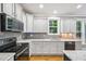 Spacious kitchen featuring ample white cabinetry, modern stainless steel appliances, and elegant gray backsplash at 1419 Endgame Ct, Wake Forest, NC 27587
