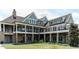 Beautiful exterior of a clubhouse featuring stone pillars, multiple balconies, and well-manicured lawn at 149 N Serenity Hill Cir, Chapel Hill, NC 27516