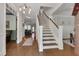 Spacious foyer with hardwood floors, staircase with white banister, and a view into the living spaces at 149 N Serenity Hill Cir, Chapel Hill, NC 27516