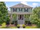 Charming two-story home with inviting front porch, manicured landscaping and stairway leading to the front door at 149 N Serenity Hill Cir, Chapel Hill, NC 27516
